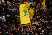 Hezbollah fighters carry the coffin of their comrade, Mohammed Ali Assaf, who was killed by an Israeli strike in Syria Friday morning, during his funeral procession in the southern Beirut suburb of Dahiyeh, Lebanon, Saturday, Nov. 11, 2023. Lebanon's militant Hezbollah group has announced the death of seven of its fighters without giving details on where they were killed. A Hezbollah official and a Lebanese security official said the seven fighters were killed in neighboring Syria Friday morning. (AP Photo/Hassan Ammar)