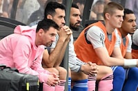 Inter Miami's Argentine forward Lionel Messi (L) sits on the bench during the friendly football match between Hong Kong XI and US Inter Miami CF in Hong Kong on February 4, 2024. Inter Miami were booed off the pitch after their injured superstar Lionel Messi failed to take the field in a pre-season friendly in Hong Kong. (Photo by Peter PARKS / AFP) (Photo by PETER PARKS/AFP via Getty Images)