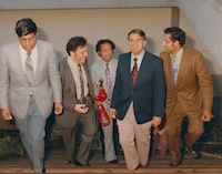 Photograph of Gurdev Singh Gill walking up a staircase along with four other men. They include the Premier of BC David Barrett, Dr. Setty Pendakur (Vancouver city councillor), Khar Sekhon (Dr. Gill's friend), Parlad Singh Gill (Dr. Gill's brother). They are all wearing formal suits and ties. The premier was invited to the Ross Street gurdwara to speak. He promised $1 million to the construction of a community centre, however, the community centre did not get built due to disagreements within the community at the time.