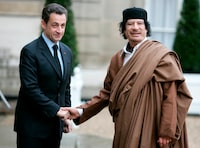 FILE - In this Dec. 10 2007 file photo, French President Nicolas Sarkozy, left, greets Libyan leader Col. Moammar Gadhafi upon his arrival at the Elysee Palace, in Paris. French prosecutors are seeking to send former President Nicolas Sarkozy to trial on charges that he received millions in illegal campaign financing from the regime of late Libyan leader Moammar Gadhafi. (AP Photo/Francois Mori, File)