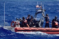 This photo provided by the U.S. Coast Guard, the crew of USCGC Oliver Henry (WPC 1140), rescues three mariners that were stranded on Pikelot Atoll, Yap State, Federated States of Micronesia, on April 9, 2024.  The stranded mariners spelled out “HELP” with palm fronds on a beach that were spotted by Coast Guard and Navy aviators, the sign pinpointed them in a search area spanning thousands of square miles. (U.S. Coast Guard photo)