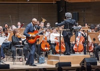 This image released by the New York Philharmonic shows former New York Yankees baseball player Bernie Williams, standing left, with conductor Gustavo Dudamel as he makes his New York Philharmonic debut in New York on Wednesday, April 24, 2024. (Brandon Patoc/New York Philharmonic via AP)