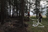 Neighbours help put out spots fires in forestry behind the Allgaier property in Neskonlith, B.C., on Aug. 20, 2023. (Aaron Hemens/The Globe and Mail)
