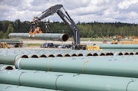 Pipe for the Trans Mountain pipeline is unloaded in Edson, Alta. on Tuesday June 18, 2019. An Indigenous-led initiative says it is still pursuing ownership of the Trans Mountain pipeline, in spite of the project's ballooning price tag. THE CANADIAN PRESS/Jason Franson