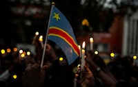 Congolese civilians light candles and hold their national flag as they pay their tributes to the victims killed following rains that destroyed the remote, mountainous area and ripped through the riverside villages of Nyamukubi, Kalehe territory in South Kivu province, during a vigil in Goma, Democratic Republic of Congo May 9, 2023. REUTERS/Stringer