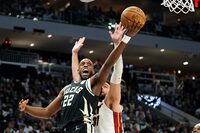 Milwaukee Bucks' Khris Middleton (22) shoots past Miami Heat's Max Strus during the second half of Game 2 of an NBA basketball first-round playoff series Wednesday, April 19, 2023, in Milwaukee. (AP Photo/Aaron Gash)