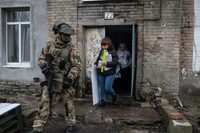 Members of a local election commission, accompanied by a serviceman, visit voters during early voting in Russia's presidential election in Donetsk, Russian-controlled Ukraine, amid the Russia-Ukraine conflict on March 14, 2024. (Photo by STRINGER / AFP) (Photo by STRINGER/AFP via Getty Images)