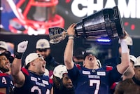 Montreal Alouettes quarterback Cody Fajardo (7) hoists the Grey Cup as fullback Alexandre Gagne (34) looks on as the Alouettes celebrate defeating the Winnipeg Blue Bombers in the 110th CFL Grey Cup in Hamilton, Ont., on Sunday, November 19, 2023. THE CANADIAN PRESS/Frank Gunn