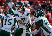 Saskatchewan Roughriders quarterback Trevor Harris, centre, hands the ball off to running back Jamal Morrow during first half CFL football action against the Calgary Stampeders in Calgary, Alta., Saturday, June 24, 2023. THE CANADIAN PRESS/Jeff McIntosh