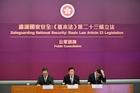 (FILES) Hong Kong Chief Executive John Lee (C), Secretary for Justice Paul Lam (L) and Secretary for Security Chris Tang (R) hold a press conference on Article 23 Legislation at government headquarters in Hong Kong on January 30, 2024. Hong Kong's proposed national security law has the city's business, human rights, and diplomacy communities troubled about government overreach in the international finance hub. (Photo by Peter PARKS / AFP) / TO GO WITH: Hong Kong-China-politics-law, by Xinqi SU and Holmes CHAN (Photo by PETER PARKS/AFP via Getty Images)