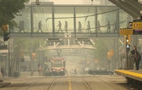 Pedestrians walk inside in the plus 15 walkway while Calgary is covered under a blanket of smoke from the forest fires in northern Alberta, May 16, 2023.  Todd Korol/The Globe and Mail