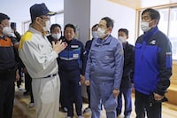 Japan's Prime Minister Fumio Kishida, front center, listens to Wajima City Mayor Shigeru Sakaguchi, front left, at an evacuation center in Wajima, Ishikawa prefecture, Japan Saturday, Jan. 13, 2024. Kishida visited the country's north-central region of Noto for the first time since the Jan. 1 quakes, amid growing criticism of slow relief work reaching those needed and concern about deteriorating health of the evacuees, many of them elderly people. (Kyodo News via AP)