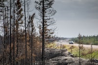 Fire activity along a key Northwest Territories highway is expected to kick up in the coming days, while Mounties say they'll stop a potentially large group from trying to re-enter when an evacuation order is still in effect. Evacuees from Yellowknife, territorial capital of the Northwest Territories, make their way along highway 3, at the edge of a burned forest, on their way into Ft. Providence, Thursday, Aug. 17, 2023. THE CANADIAN PRESS/Bill Braden