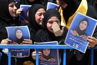 Students cry during the funeral of their classmate who was killed Tuesday by an Israeli strike on a house in the town of Hanin, at the backyard of Hezbollah-run Al-Mahdi school, in Tiri village, south Lebanon, Thursday April 25, 2024. Hezbollah militants and Israeli forces have been exchanging fire since a day after the Israel-Hamas war began on Oct. 7. (AP Photo/Mohammed Zaatari)