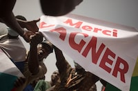 Protesters holds a banner reading "Thank you Wagner", the name of the Russian private security firm present in Mali,  during a demonstration organised by the pan-Africanst platform Yerewolo to celebrate France's announcement to withdraw French troops from Mali, in Bamako, on February 19, 2022. - The French president announced on Febraury 16 the withdrawal of troops from Mali after a breakdown in relations with the nation's ruling military junta. France first intervened in Mali in 2013 to combat a jihadist insurgency that emerged one year prior. The French pull-out after nearly a decade is also set to see the smaller European Takuba group of special forces, created in 2020, leave Mali. (Photo by FLORENT VERGNES / AFP) (Photo by FLORENT VERGNES/AFP via Getty Images)