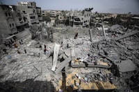 Palestinians inspect the damage to a residential building for the Moussa family after an Israeli airstrike in the Maghazi refugee camp, central Gaza Strip, Friday, March 29, 2024. (AP Photo/Ismael Abu Dayyah)