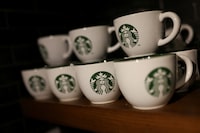 FILE PHOTO: Branded coffee mugs are displayed in Starbucks' outlet at a market in New Delhi, India, May 30, 2023. REUTERS/Anushree Fadnavis/File Photo