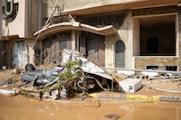 This handout picture provided by the office of Libya's Benghazi-based interim prime minister on September 11, 2023 shows a view of a destroyed vehicle by damaged buildings in the eastern city of Derna, about 290 kilometres east of Benghazi, in the wake of the Mediterranean storm "Daniel". At least 150 people were killed when freak floods hit eastern Libya, officials said on September 11, after the storm's torrential rains battered Turkey, Bulgaria, and Greece. (Photo by The Press Office of Libyan Prime Minister / AFP) / === RESTRICTED TO EDITORIAL USE - MANDATORY CREDIT "AFP PHOTO / HO /MEDIA OFFICE OF LIBYAN PRIME MINISTER (BENGHAZI)" - NO MARKETING NO ADVERTISING CAMPAIGNS - DISTRIBUTED AS A SERVICE TO CLIENTS === (Photo by -/The Press Office of Libyan Prime/AFP via Getty Images)