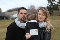 Licinio and Kim Santos hold their son, Austin, as well as an embryo photo of him in Kelowna, B.C., on Feb. 29, 2024. (Aaron Hemens/The Globe and Mail)