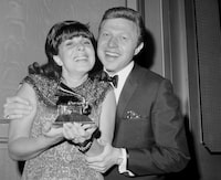 FILE - Singer Eydie Gorme, with her husband Steve Lawrence, holds the Grammy she was presented as the top female vocalist of 1966 for her recording of "If He Walked Into My Life," at the Grammy Awards in New York on March 3, 1967. Lawrence, a singer and top stage act who as a solo performer and in tandem with his Gorme kept Tin Pan Alley alive during the rock era, died Wednesday, March 6, 2024 at age 88. Gorme died on Aug. 10, 2013. (AP Photo/Marty Lederhandler, File)