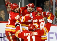 Calgary Flames defenceman MacKenzie Weegar, centre, celebrates his goal with teammates during overtime NHL hockey action against the Vegas Golden Knights in Calgary, Alta., Monday, Nov. 27, 2023. THE CANADIAN PRESS/Jeff McIntosh