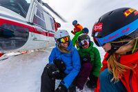 Guides unload the gear, while everyone braces for the rotor-wash snow bath that comes when the heli takes off.