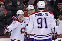 Montreal Canadiens right wing Cole Caufield (22) is congratulated by Justin Barron and Sean Monahan (91) after scoring a goal against the New Jersey Devils during the third period of an NHL hockey game Wednesday, Jan. 17, 2024, in Newark, N.J. (AP Photo/Adam Hunger)