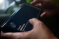 A person holds a smartphone set to the opening screen of the ArriveCan app in a photo illustration made in Toronto on June 29, 2022. The federal government announced on Monday that starting Oct. 1, all COVID-19 entry restrictions will be removed, including testing, quarantine and isolation requirements for anyone entering Canada. THE CANADIAN PRESS/Giordano Ciampini