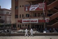 Medics walk in front of the emergency ward at Nasser Hospital where bodies were discovered, in Khan Yunis in the southern Gaza Strip on April 23, 2024 amid the ongoing conflict between Israel and the Palestinian militant group Hamas. (Photo by AFP) (Photo by -/AFP via Getty Images)