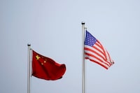 FILE PHOTO: Chinese and U.S. flags flutter outside a company building in Shanghai, China April 14, 2021. REUTERS/Aly Song