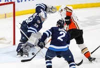Winnipeg Jets goaltender Laurent Brossoit (39) saves the shot from Anaheim Ducks' Jakob Silfverberg (33) as Dylan DeMelo (2) defends during second period NHL action in Winnipeg, Friday, March 15, 2024. THE CANADIAN PRESS/John Woods