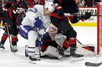 Toronto Maple Leafs' Pontus Holmberg (29) and Carolina Hurricanes goaltender Frederik Andersen, center, battle for control of the puck during the third period of an NHL hockey game in Raleigh, N.C., Sunday, March 24, 2024. (AP Photo/Karl B DeBlaker)