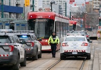 Toronto's transit system has seen a number of violent attacks in recent days, as political, transit and police leaders vow to make the system safer. Police cars surround a TTC streetcar on Spadina Avenue, in Toronto on Tuesday, January 24, 2023. THE CANADIAN PRESS/Arlyn McAdorey