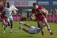 Canada's Phil Berna, right, is tackled by Lucas Lacamp from the U.S., during a match of the Emirates Airline Rugby Sevens, in Dubai, United Arab Emirates, Friday, Dec. 2, 2022. (AP Photo/Kamran Jebreili)