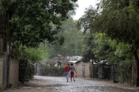 FILE PHOTO: Women walk under the rain in the Malfety neighborhood of Fort Liberte, Haiti April 27, 2024. REUTERS/Ricardo Arduengo/File Photo