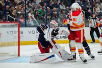 Oct 20, 2023; Columbus, Ohio, USA;  Calgary Flames center Nazem Kadri (91) deflects the puck under the mask of Columbus Blue Jackets goaltender Spencer Martin (30) in the second period at Nationwide Arena. Mandatory Credit: Aaron Doster-USA TODAY Sports