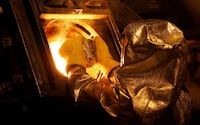 Senior refinery technician Vincente Sandoval puts a gold "button" into a furnace to be further refined to form gold dore bars at Newmont Mining's Carlin gold mine operation near Elko, Nevada, U.S., May 21, 2014.