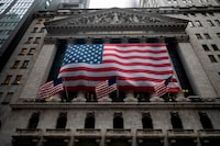 The US flag is seen at the New York Stock Exchange (NYSE) on April 30, 2020 in New York City. - Wall Street stocks opened lower Thursday following another spike of jobless claims in the wake of coronavirus shutdowns, offsetting strong results from tech giants. Another 3.84 million US workers filed for unemployment benefits last week and the total has now passed 30 million in six weeks, according to the Labor Department data. (Photo by Johannes EISELE / AFP) (Photo by JOHANNES EISELE/AFP via Getty Images)