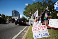 A small crowd holding signs and waving as cars pass by the Leon County Courthouse, protests Sb 300, which bans abortions after six weeks, Thursday, April 13, 2023. in Tallahassee, Fla. The Republican-dominated Florida Legislature on Thursday approved a ban on abortions after six weeks of pregnancy, a proposal supported by GOP Gov. Ron DeSantis as he prepares for an expected presidential run. (Alicia Devine/Tallahassee Democrat via AP)