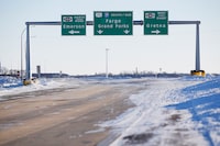 FILE - Road signage is posted just outside of Emerson, Manitoba on Thursday, Jan. 20, 2022. A man accused of helping to lead a human smuggling operation that was implicated in the deaths of a family of four from India — who froze while trying to walk across the Canada-U.S. border during a blizzard in 2022 — had been warned about dangerous weather conditions before the group set out on the trip, court papers alleged. (John Woods/The Canadian Press via AP, File)