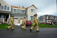 Emergency crew work outside damaged homes following a tornado in the Ottawa suburb of Barrhaven on Thursday, July 13, 2023. THE CANADIAN PRESS/Sean Kilpatrick