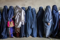 FILE - Afghan women wait to receive food rations distributed by a humanitarian aid group, in Kabul, Afghanistan, Tuesday, May 23, 2023. Two top international rights groups on Friday, May 26, slammed the severe restrictions imposed on women and girls by the Taliban in Afghanistan, saying they amount to the “crime against humanity of gender persecution.” (AP Photo/Ebrahim Noroozi, File)