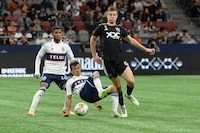Sep 30, 2023; Vancouver, British Columbia, CAN;  Vancouver Whitecaps FC midfielder Andres Cubas (20) battles for the ball against D.C. United midfielder Chris Durkin (8) during the second half at BC Place. Mandatory Credit: Anne-Marie Sorvin-USA TODAY Sports