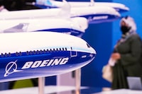 FILE - A woman walks by models of Boeing Co. aircraft, including the manufacturer's new Boeing 777X, at the Dubai Air Show in Dubai, United Arab Emirates, Wednesday, Nov. 17, 2021. Boeing reports their earnings on Wednesday, Jan. 31, 2024. (AP Photo/Jon Gambrell, File)
