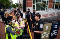 WASHINGTON, DC - MAY 8: Demonstrators talk to a George Washington University police officer as law enforcement block H Street near George Washington University's University Yard on May 8, 2024 in Washington, DC. Pro-Palestinian encampments have sprung up at college campuses around the country with some demonstrators calling for schools to divest from Israeli interests amid the ongoing war in Gaza. (Photo by Kent Nishimura/Getty Images)