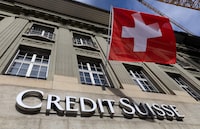 FILE PHOTO: A Swiss flag is pictured above a logo of Swiss bank Credit Suisse in Bern, Switzerland, November 15, 2023. REUTERS/Denis Balibouse/File Photo