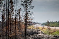 Evacuees from Yellowknife, territorial capital of the Northwest Territories, make their way along highway 3, at the edge of a burned forest, on their way into Ft. Providence, N.W.T., Thursday, Aug. 17, 2023.