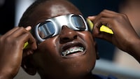 Blake Davis, 10, of Coral Springs, Fla., looks through solar glasses as he watches the eclipse, Monday, Aug. 21, 2017, at Nova Southeastern University in Davie, Fla.