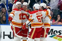 TAMPA, FL - MARCH 07: Yegor Sharangovich #17 of the Calgary Flames, second from left, celebrates his goal against the Tampa Bay Lightning with Jonathan Huberdeau #10 and MacKenzie Weegar #52 during the second period at the Amalie Arena on March 7, 2024 in Tampa, Florida. (Photo by Mike Carlson/Getty Images)