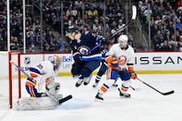 New York Islanders goaltender Ilya Sorokin (30) makes a save as Winnipeg Jets' Vladislav Namestnikov (7) jumps out of the way of the shot during the second period of NHL action in Winnipeg on Tuesday January 16, 2024. THE CANADIAN PRESS/Fred Greenslade
